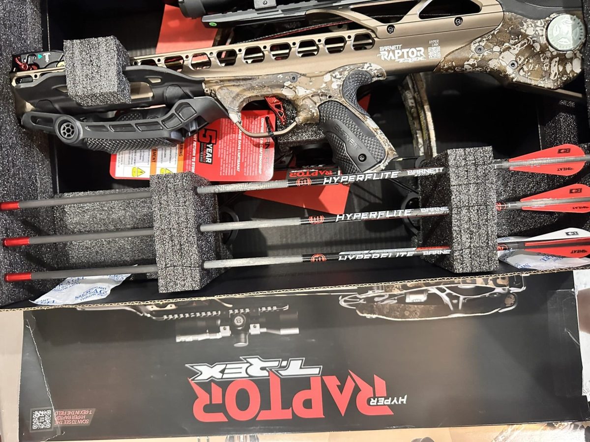 Camouflage Barnett HyperLite crossbow secured in foam-lined case with arrows visible nearby.