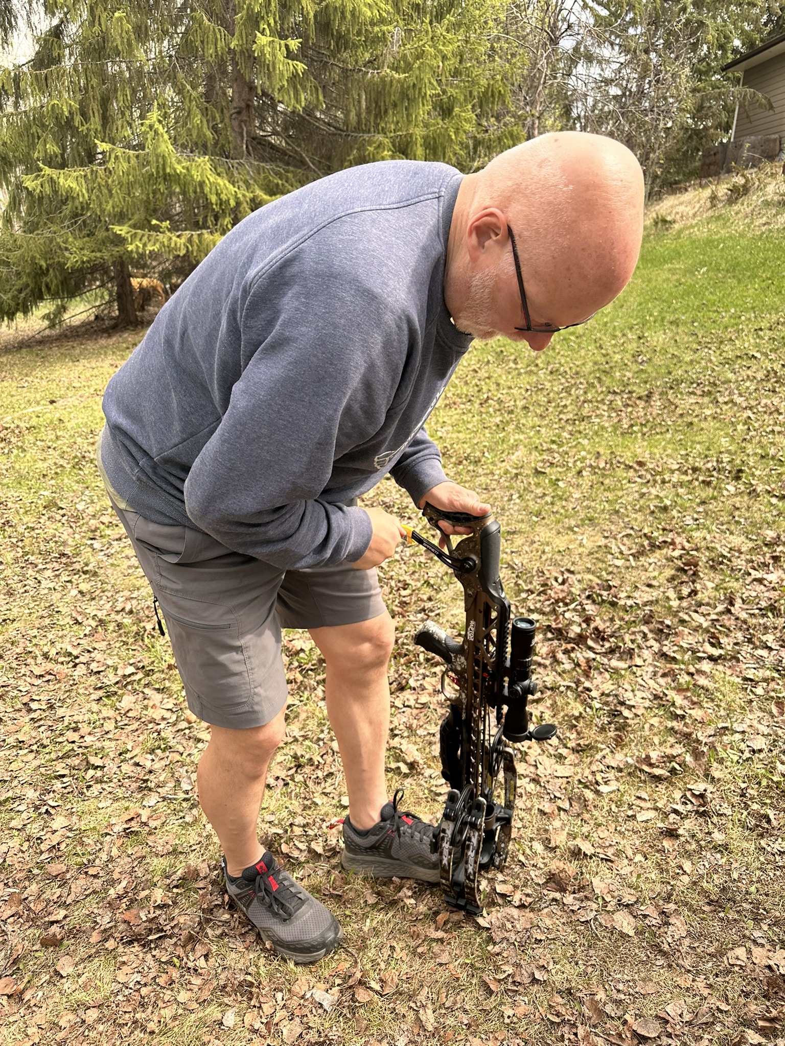 Man bending over a crossbow